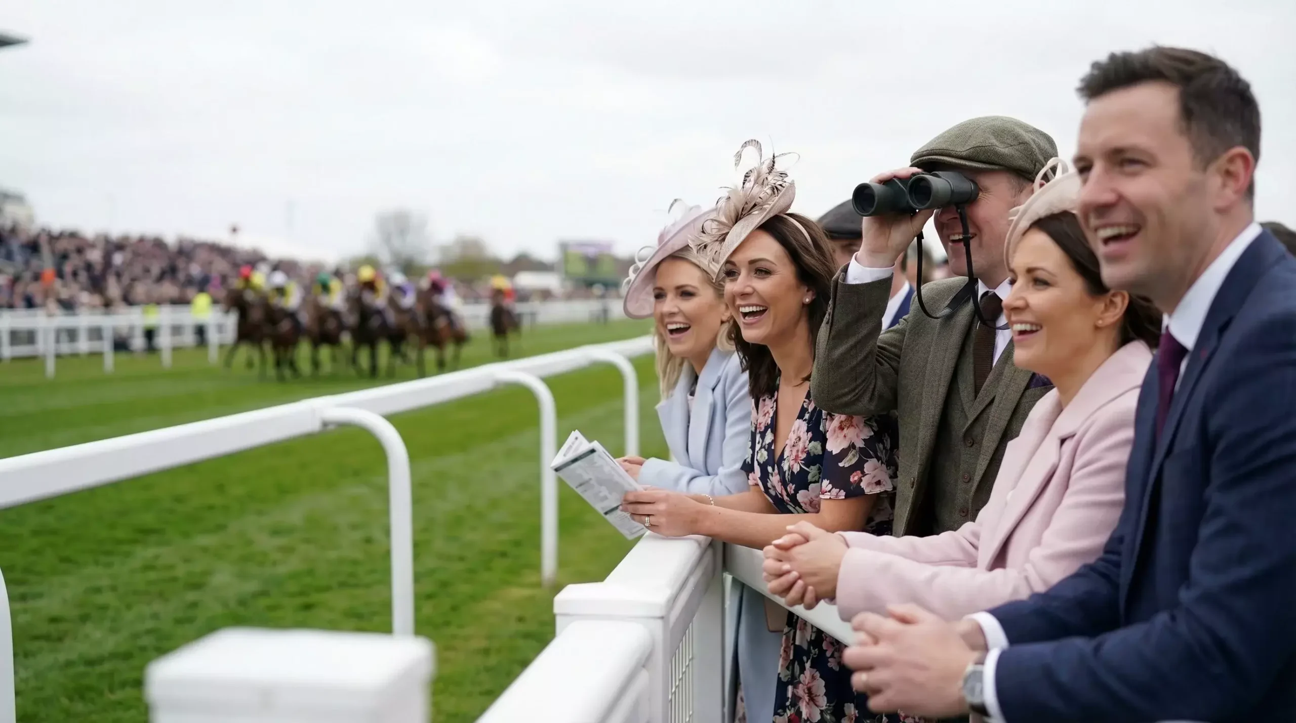 Crowd of British punters watching horse race at Aintree racecourse
