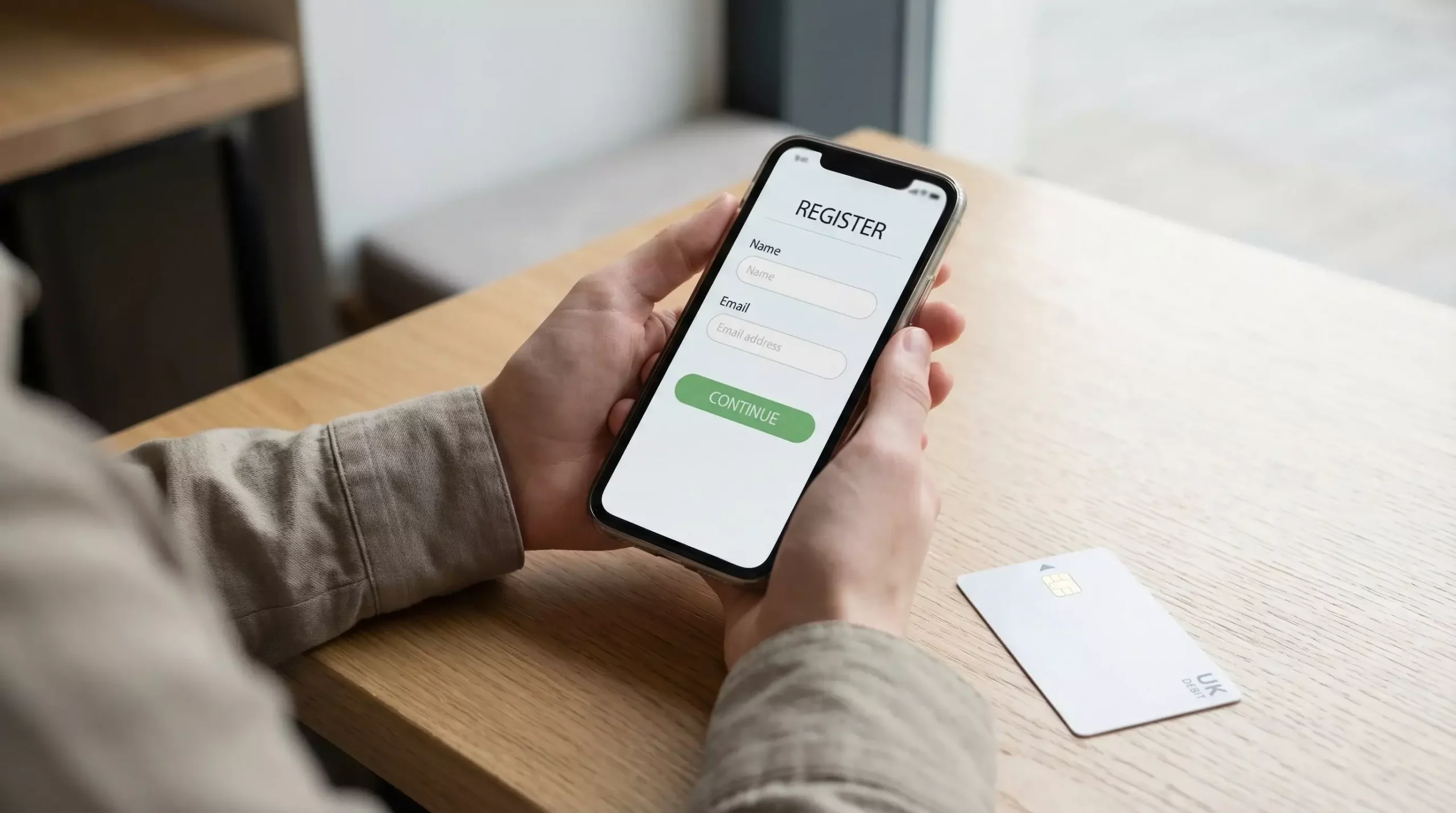 Smartphone showing betting app registration form with UK debit card